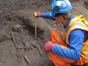 An archaeologist working to uncover skeletons from what is understood to be a mass grave for victims of the Black Death, discovered when excavations were made to create a Crossrail tunnel shaft under Charterhouse Square in central London.